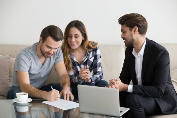 A man and a woman signing paperwork