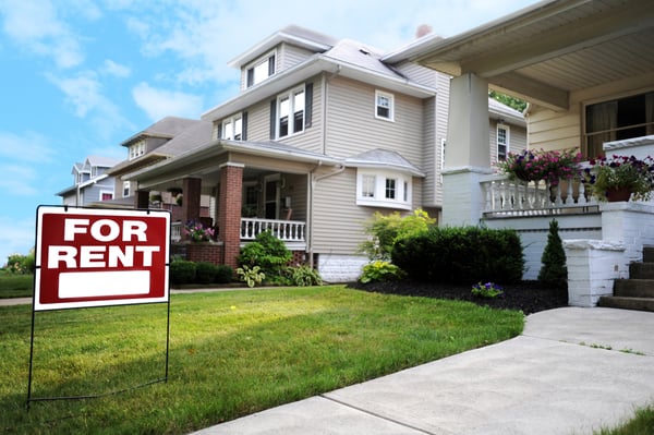 A home with a "for rent" sign in the front yard