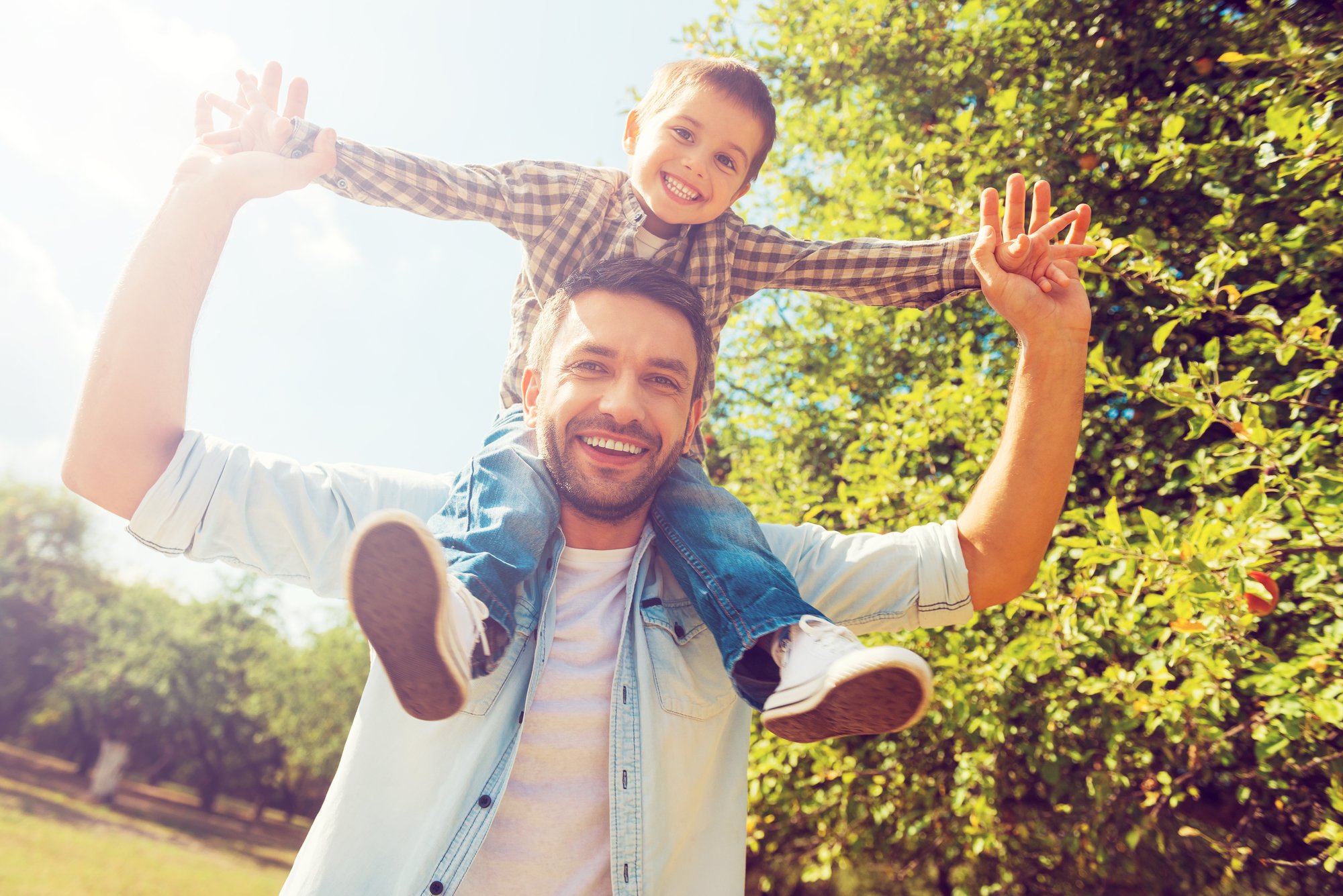 Father carrying little boy on shoulders