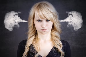 Closeup portrait of angry young woman, blowing steam coming out of ears, about to have nervous atomic breakdown, isolated black background. Negative human emotions facial expression.