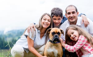 Happy family with a dog enjoying the countryside lifestyle